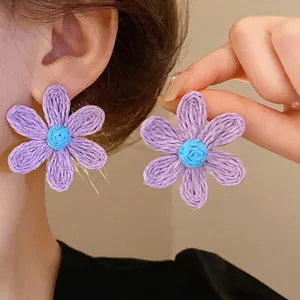 Handmade bohemian purple woven flower stud earrings with blue centers for women