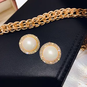 Dettaglio di orecchini a perla vintage francesi con un alone di cristalli scintillanti.