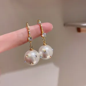 Vista dettagliata di eleganti orecchini retrò con perle, accenti di cristallo e oro