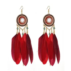 Bohemian ethnic style earrings featuring vibrant red feathers and gold-toned bead details.