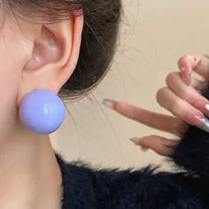 Orecchino geometrico a sfera viola su modella per un uso quotidiano versatile ed elegante