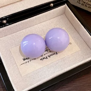 Orecchini a perno sferici color lavanda con aghi d'argento in un portagioie elegante