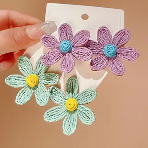 Macro detail of Bohemian woven flower earrings featuring vibrant colors and woven textures.