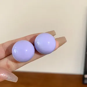 Vista dettagliata degli orecchini a sfera lavanda con una finitura liscia e lucida