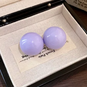 Primo piano di eleganti orecchini a sfera lavanda con perni in argento massiccio