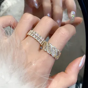 Primo piano di un elegante anello aperto a spirale con zirconi e perle indossato al dito.
