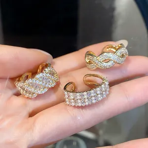 Vista dettagliata di eleganti anelli dorati in zircone con motivi intrecciati e perle.