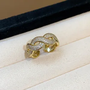 Primo piano di un anello intrecciato placcato oro con micro pavé di zirconi cubici