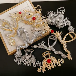 Close-up of elegant gold and silver dragon hair claw clips with rhinestones