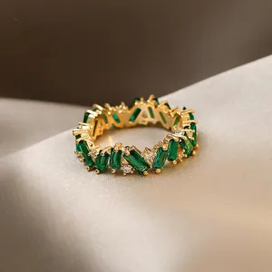 Detail of vintage gold-plated ring with emerald green zircon and crystals.