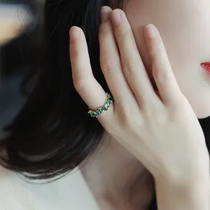 Detailed macro view of a vintage gold-plated ring featuring geometric green zircon stones