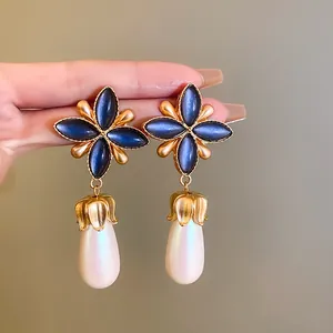 Orecchini vintage francesi con petali blu scuro e grandi perle bianche a forma di goccia.