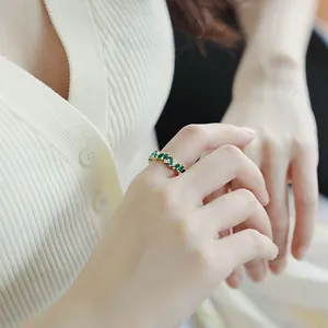 Close-up view of a vintage style gold plated ring featuring emerald green cubic zirconia.
