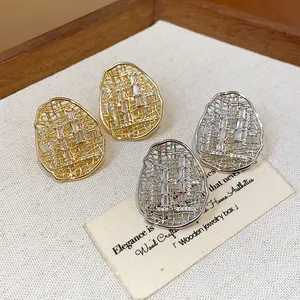 Detailed view of hollow irregular oval stud earrings with sparkling cubic zirconia