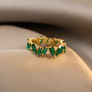 Close-up detail of a vintage gold-plated ring with emerald green geometric zircons.
