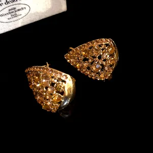 Dettaglio di eleganti orecchini vintage a goccia con strass color ambra scintillanti