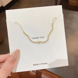 Detailansicht eines goldfarbenen Wellenarmbands mit funkelnden Steinen auf Karte