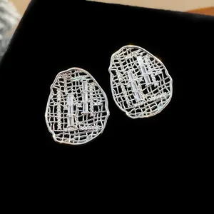 Detail view of luxury gold-plated oval hollow earrings with cubic zirconia inlay.
