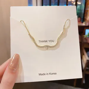 Detailansicht eines eleganten goldenen Wellenarmbands mit funkelnden Strasssteinen auf Karte