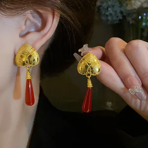 Primo piano di orecchini vintage a cuore francesi con pendenti a goccia rossi.