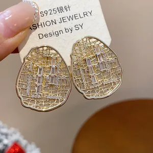 Close-up view of elegant gold plated oval hollow stud earrings with sparkling cubic zirconia