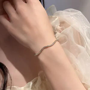Detailansicht eines funkelnden zierlichen Wellenarmbands mit Kristallen am Handgelenk