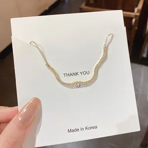 Detailansicht eines funkelnden goldfarbenen Wellenarmbands mit klaren Strasssteinen
