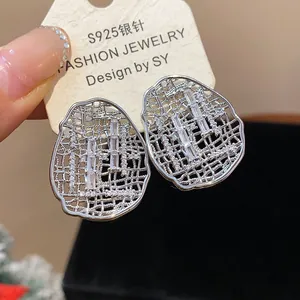 Detailed view of silver oval hollow stud earrings featuring sparkling baguette zirconia