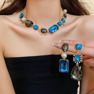 Detail view of French luxury necklace and earrings with blue crystals and pearls.