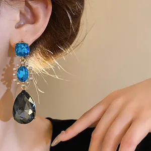 Close-up of elegant French vintage drop earrings featuring blue crystals and grey teardrop stones