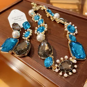 Detailed view of a vintage French luxury necklace and earring set with crystals and pearls.