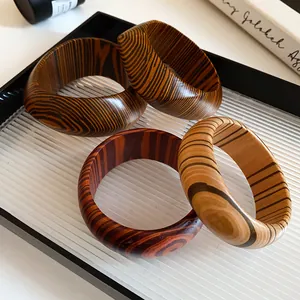Detailed view of four vintage bangles with unique wooden patterns and bold textures