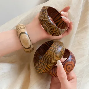 Detailed view of wide retro wooden bangles showcasing diverse natural wood grain textures