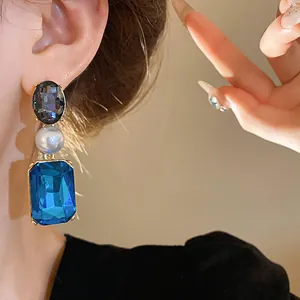 Detailed close-up view of French vintage dangling earrings featuring blue crystals and pearls