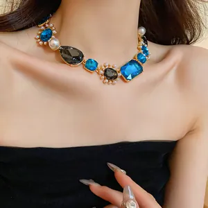 Macro view of blue crystal and pearl details on vintage French style necklace on model