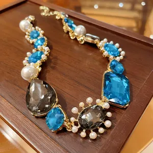 Detailed view of French vintage necklace with blue crystals and white pearls on wood