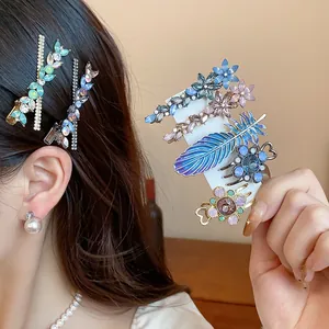 Close-up of rhinestone flower and feather hair clips shown as wearing effect and on card