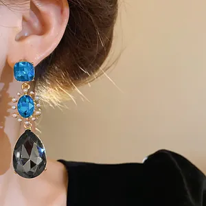Detailed view of French vintage drop earrings with blue crystals and grey teardrop stone