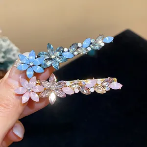Detail view of elegant rhinestone resin flower hair clips in vibrant blue and soft pink tones.