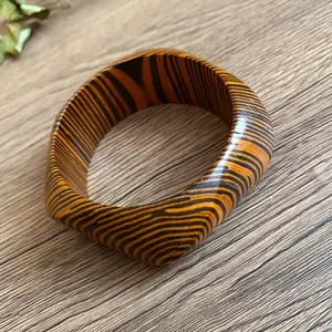 Close-up detail of retro square bangle featuring a bold orange and black zebra stripe pattern