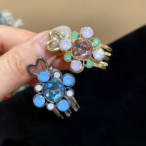 Close-up of exquisite rhinestone flower hair clips with colorful resin crystal accents.