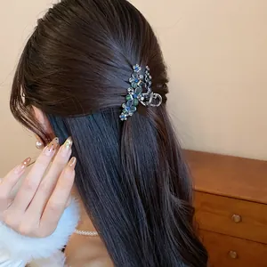 Macro view of a sparkling rhinestone resin flower hair clip styled on dark hair for elegant look