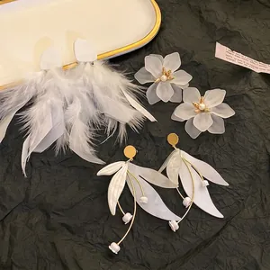 Elegant set of white feather and floral stud earrings with gold accents for women