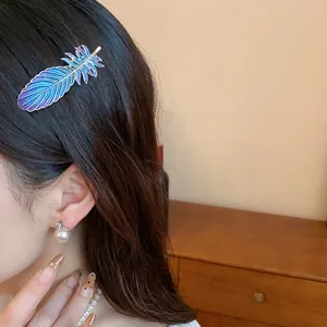 Exquisite blue and purple resin feather hair clip shown as a close-up on model's dark hair
