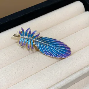 Detail view of an elegant blue and purple gradient enamel feather hair clip
