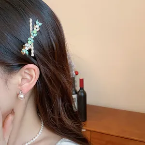 Macro view of an elegant rhinestone resin flower feather hair clip on wavy brown hair