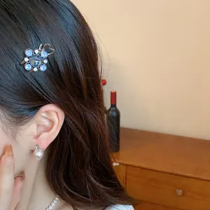 Elegant blue floral rhinestone duckbill hair clip shown on model for fashion detail.