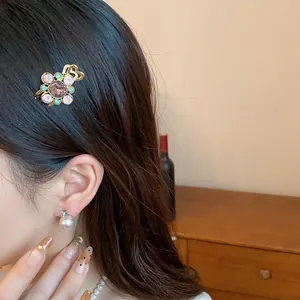 Close-up detail of an elegant floral rhinestone hair clip styled on a model's long dark hair