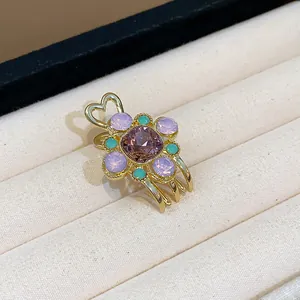 Detailed close-up of elegant flower hair clip with purple gems and gold heart design
