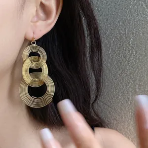 Elegante goldene Dreifach-Spiral-Ohrhänger am Model für einen luxuriösen Look